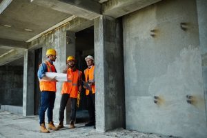 Two Workmen Showing Unfinished Floors In Highrise Building